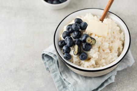 Rice milk porridge with blueberries in a bowl close-up. The concept of a healthy and tasty breakfast.の写真素材