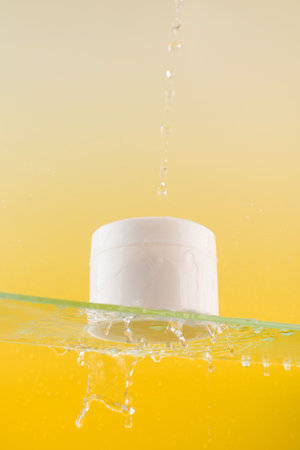 White jar with cream or mask for face and body with place for your logo on a glass shelf with water splashesの写真素材