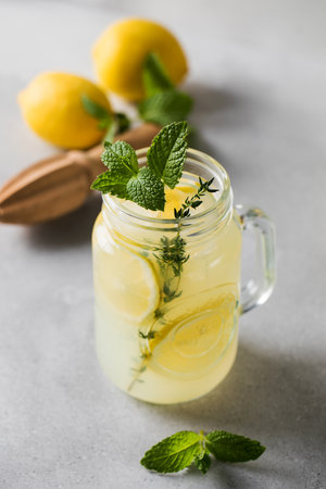 Homemade lemonade with fresh lemon slices and mint leaves in a glass. A summer refreshing drink.の写真素材
