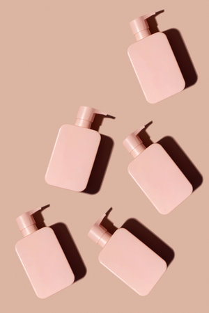 Pattern pink cosmetic product layout with a place for a logo on a pink background. Shampoo, shower gel.の写真素材