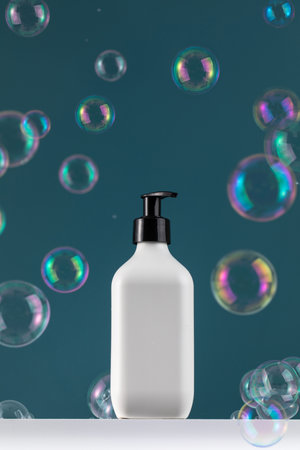 Empty white plastic dispenser bottles with soap or shampoo on a white shelf with flying soap bubbles.の写真素材