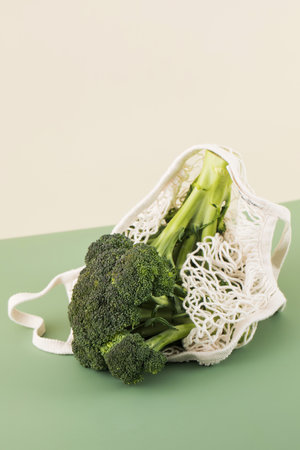 Fresh broccoli in a cotton bag on a green background. The concept of healthy food, vegetables.の写真素材