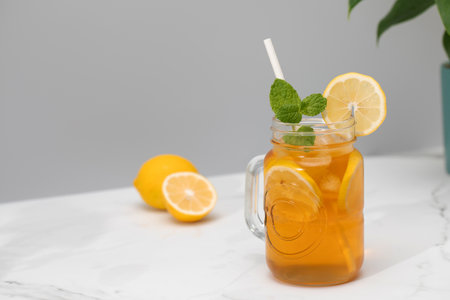 A glass of cold tea, ice cubes, lemon slices and a sprig of mint. Cooling summer drinks.の写真素材