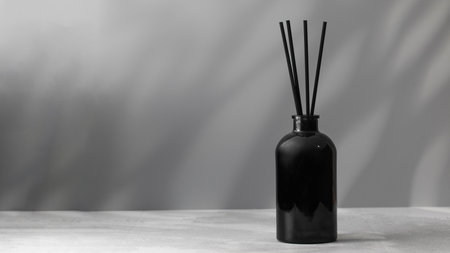 Bamboo sticks in a black bottle with indoor perfumes. Glass diffuser with fragrance. Copy spaceの写真素材