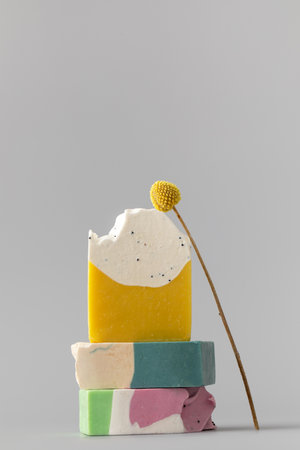 Natural handmade soap. Bright pieces of soap are stacked on top of each other on a gray background.