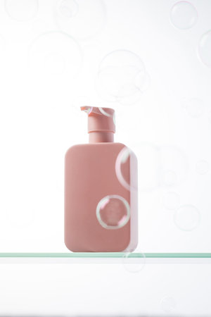 Cosmetic for routine skin and hair care on a glass shelf and flying bubbles.の写真素材
