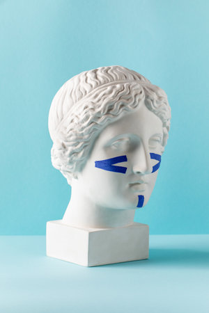 Blue tapes for the face on the bust on a blue background. Non-surgical facelift, rejuvenation.の写真素材