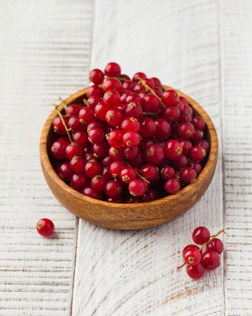 Ripe juicy red currant in a wooden bowl. Fresh berries.