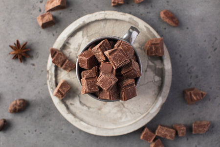 Pieces of natural milk chocolate and cocoa beans in bowls. Natural products, artisan chocolate.の写真素材