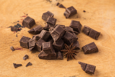 Cubes of dark artisan chocolate on a wooden background. Bitter chocolateの写真素材