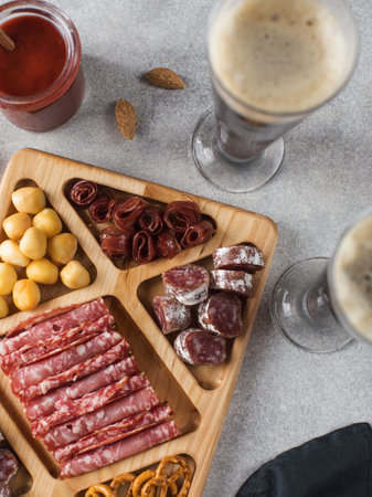 Wooden menagerie with beer snacks. A plate with assorted sausages, cheese, crackers.の写真素材