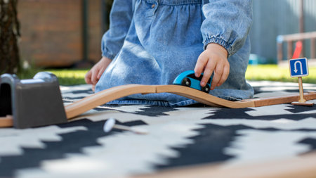 Close-up of a childs hands playing with a wooden train on the railway. Childrens developmentの写真素材