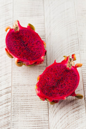 Pitaya or dragon fruit cut in half on a light wood background. Tropical fruits.の写真素材