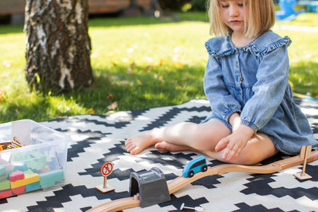 Funny little girl is playing a wooden construction set. The concept of educational games.の写真素材