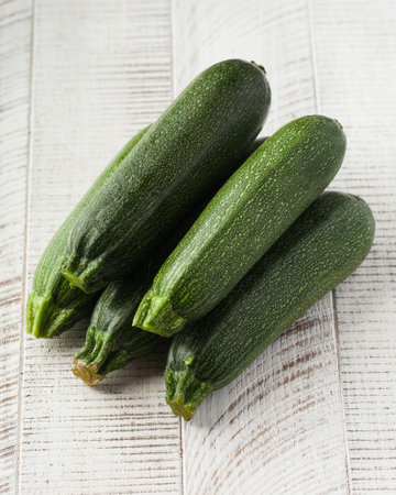 Green raw zucchini on a white wooden background. Vegetables, harvesting.の写真素材