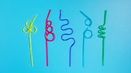 Colorful plastic cocktail straws on a blue background. Flat layの写真素材