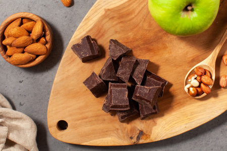 Cubes of dark artisan chocolate. Dark chocolate chunks with almonds and fresh applesの写真素材