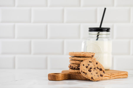 Cookies are spread out on a plate, a glass of fresh milk. Homemade cookies with chocolate chips.の写真素材