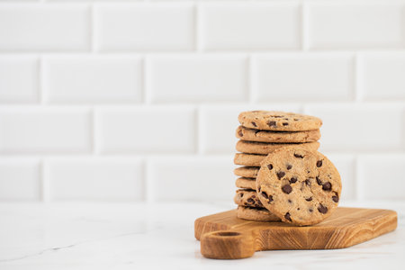 Stacked chocolate chip cookies on a wooden boardの写真素材