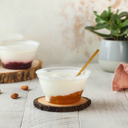 Delicious yogurt with apricot jam, beautifully served in a clear plastic cupの写真素材