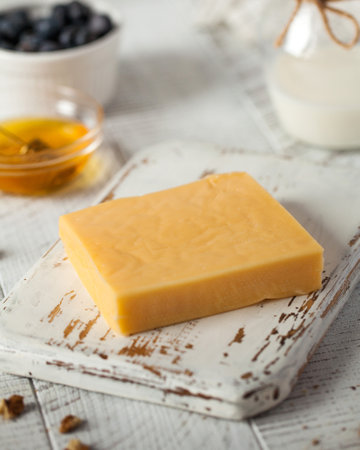 Craft cheese piece on rustic wooden board in kitchen