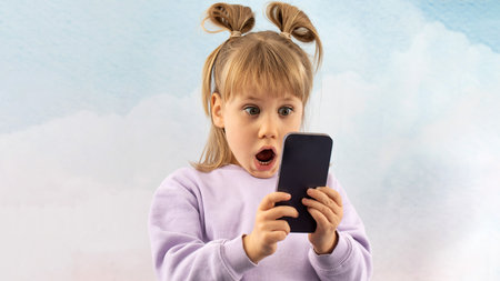 Shocked junior schoolgirl stares at phone screen gaping mouth