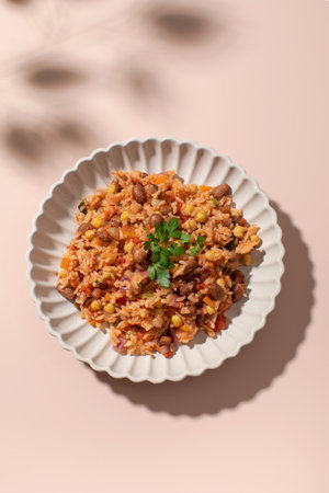 Jambalaya with rice chickpeas and kidney beans on pink tableの写真素材