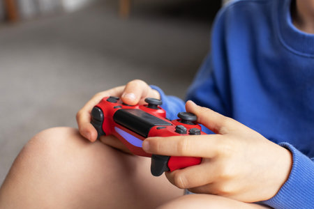 Close-up of a boys hands holding a game controller. Video games, game consoles.