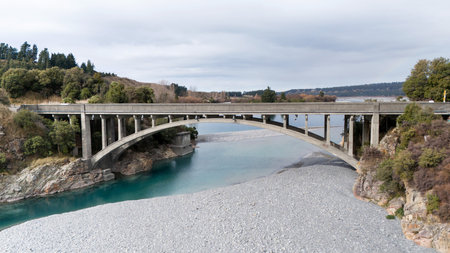 Automobile bridge crosses river with water frozen near banksの写真素材