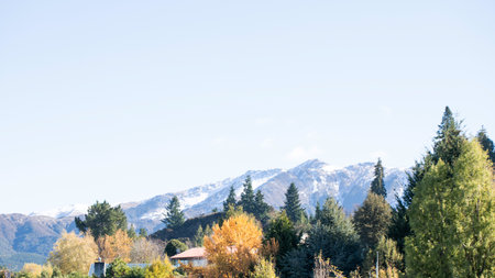 Experience the breathtaking beauty of an autumn mountain landscape with majestic, snowcapped peaksの写真素材