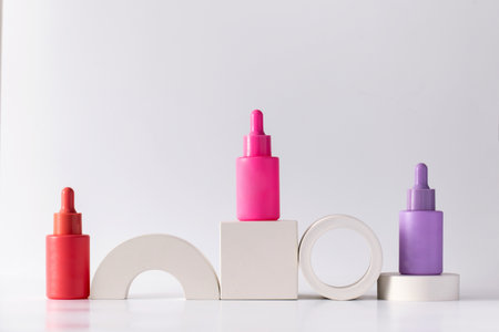 Bright colored vials with pipettes with anti-aging skin serum on podiums.の写真素材