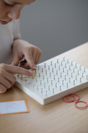 A Child Actively Engaged in a Fun Creative Rubber Band Art Activity Within His Home Environment