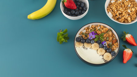A healthy nutritious breakfast of natural Greek yoghurts, granola and fresh berries. Copy space