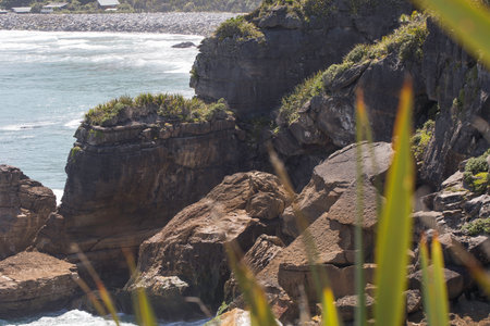 Coastal cliffs and ocean waves with lush foliage. Punakaiki, New Zealand.の写真素材