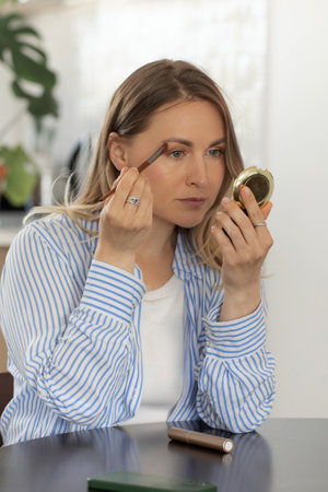 Pretty woman applies mascara onto eyelashes at home. Beauty productの写真素材