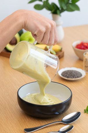 Preparing healthy avocado smoothie in kitchen settingの写真素材