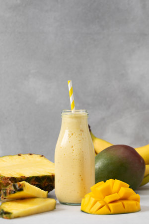 Refreshing tropical smoothie with mango, pineapple, and banana for a summer beverage delightの写真素材