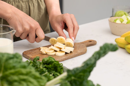 Woman cutting banana on cutting board. Fruit, healthy foodの写真素材