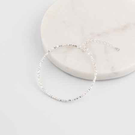 Minimalist silver chain bracelet on marble surface with adjustable claspの写真素材