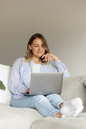 Relaxed woman enjoying leisure time with laptop at home. Working at homeの写真素材