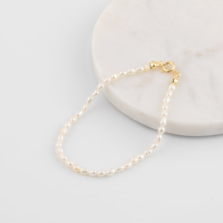 Elegant pearl bracelet with gold clasp on marble surfaceの写真素材