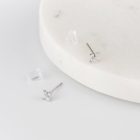 Elegant minimalist stud earrings with clear gemstones on white surface. Jewelleryの写真素材