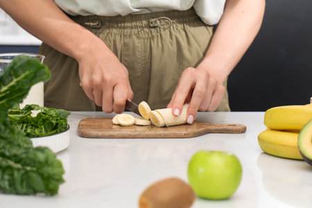 Woman cutting banana on cutting board. Fruit, healthy foodの写真素材