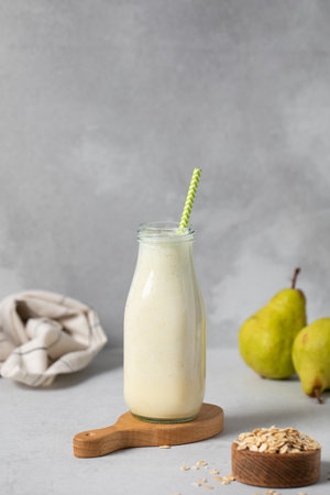 Refreshing pear and oat smoothie in glass bottle for healthy breakfastの写真素材