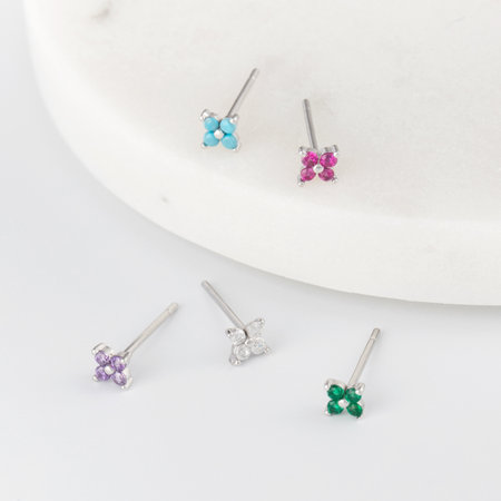Assorted elegant minimalist stud earrings with clear gemstones on white surface. Jewelersの写真素材