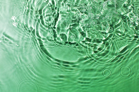 Abstract ripples and bubbles in green water surface for creative designの写真素材