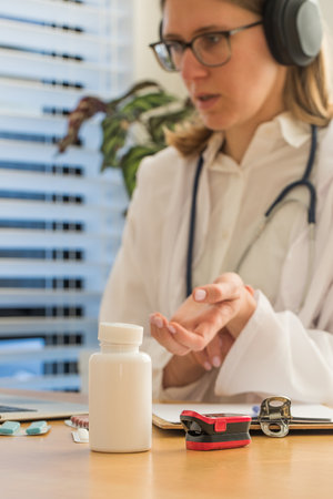 Female doctor demonstrates how to measure pulse during online consultation. Medicines