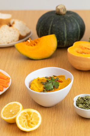 Creamy pumpkin hummus with fresh herbs and chopped vegetables. Healthy food concept.の写真素材