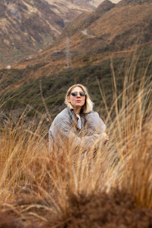 Woman in sunglasses exploring autumn mountain landscapeの写真素材