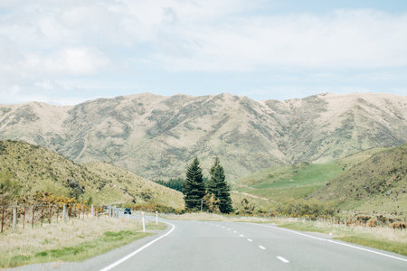 Scenic mountain road in serene countryside landscape for adventure travel and explorationの写真素材